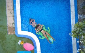 2 kids floating in a swimming pool